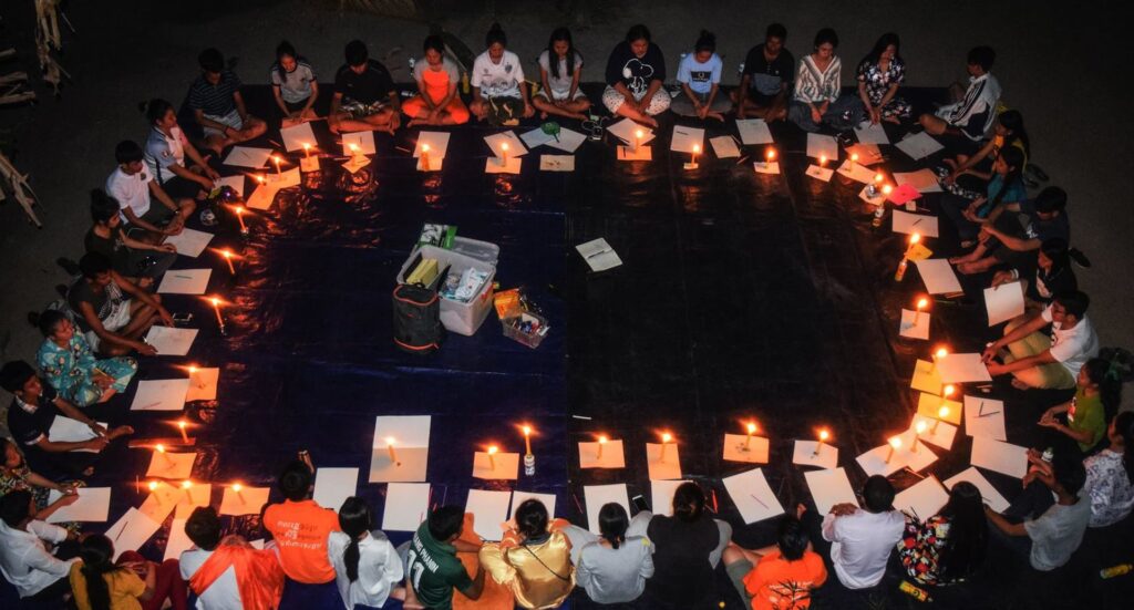 People in a circle with lit candles
